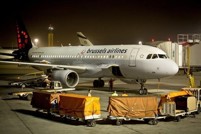 Самолет Brussels Airlines в аэропорту в окружении грузов