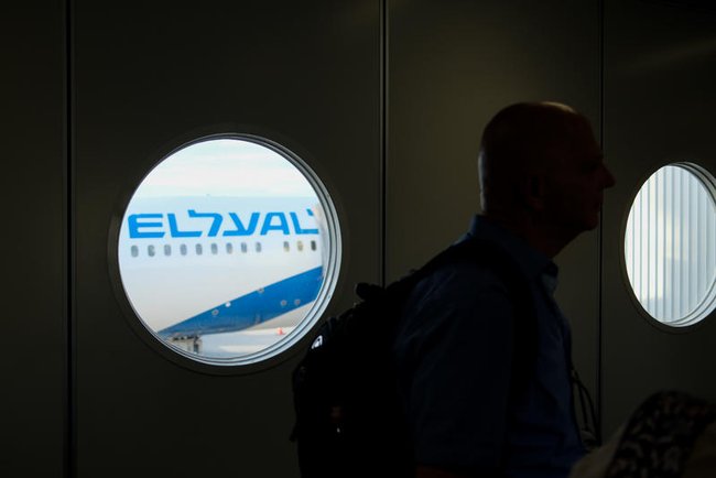 Самолет EL AL в светлом иллюминаторе на темном фоне, темная фигура человека