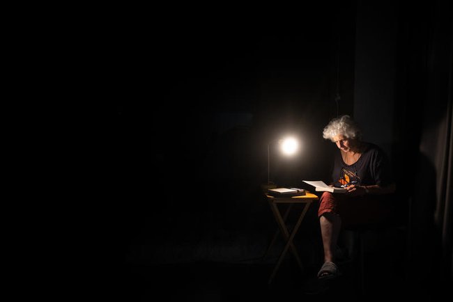 Женщина читает книгу в темном пространстве