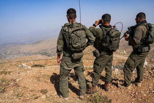 Три израильских солдата спиной на сирийской стороне горы Хермон