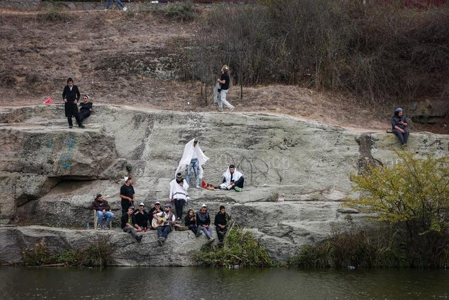 Еврейские паломники в Умани на камнях у водоема