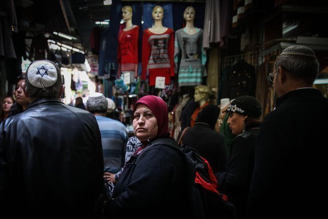 Мусульманка в никабе огладывается, рядом с ней двое мужчин в кипах