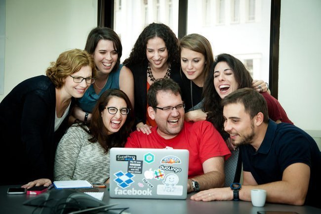 Люди смотрят в компьютер и улыбаются