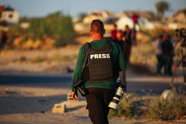 Человек в жилете с надписью Press