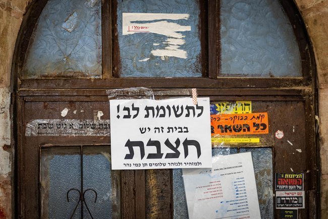 Предостережение о случае кори на двери дома в иерусалимском районе Меа-Шеарим.