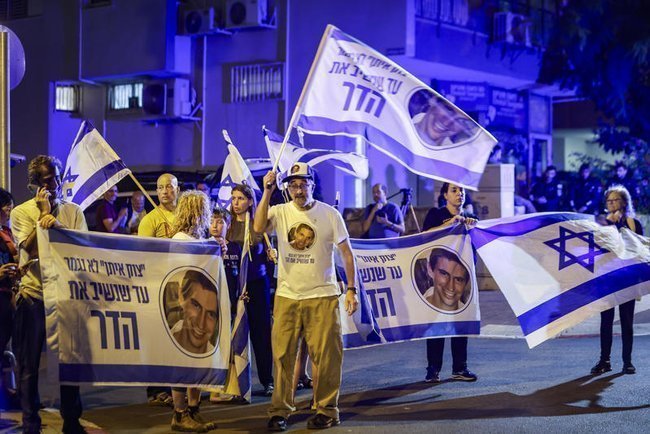 Израильтяне с флагами и портретами Адара Голдина