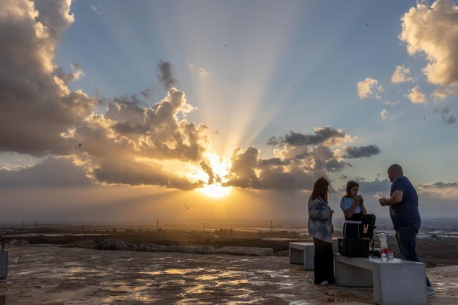 Люди на фоне заката сквозь облака