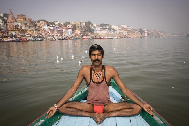 Индиец занимается йогой в собственной лодке.