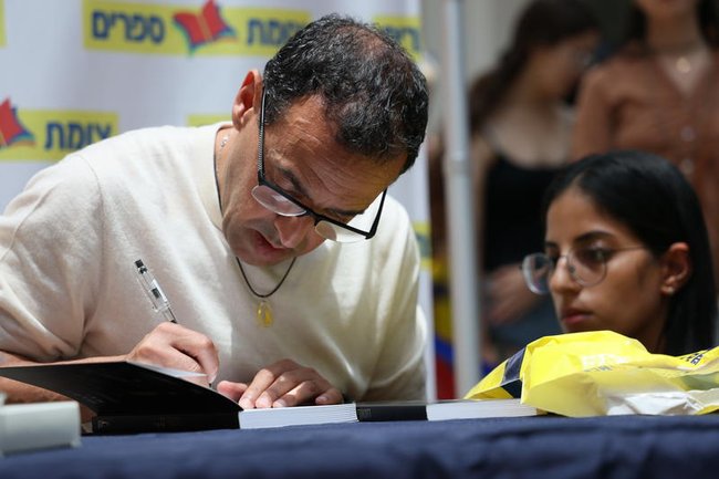 Эли Шараби подписывает свою книгу «Заложник» на мероприятии в Модиине.