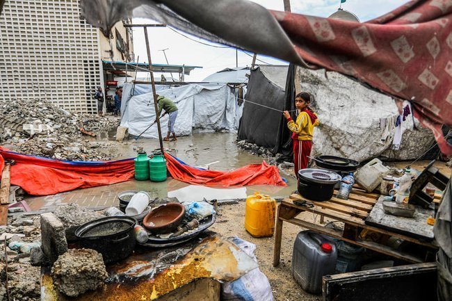 Палестинская девочка в секторе Газа у палатки после дождя