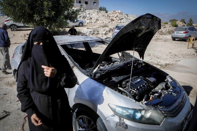 Женщина в никабе на фоне автомобиля.