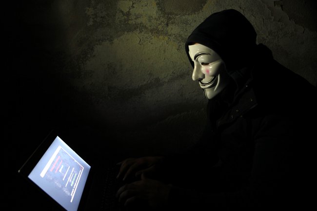 Мужчина в маске перед компьютером