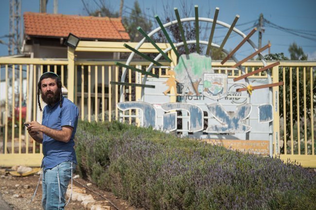 Цви Суккот стоит у ворот еврейского поселения Ицхар, недалеко от форпоста «Коми Ори»