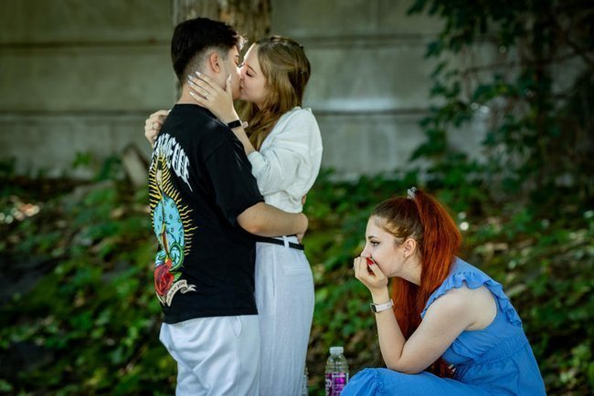 Целующаяся пара и скучающая девушка