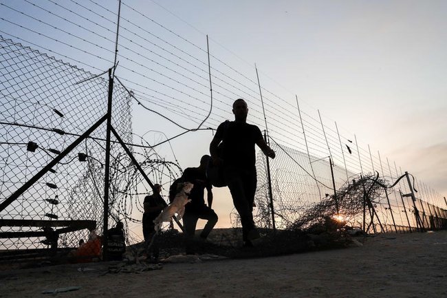 Нелегальные палестинские рабочие проникают в Израиль через дыру в заборе безопасности.