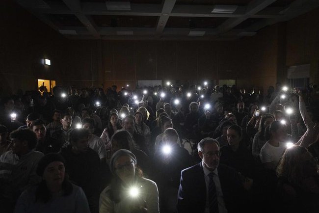 Люди на церемонии в память о жертвах массового расстрела еврейской общины в Сиднее во время празднования Хануки