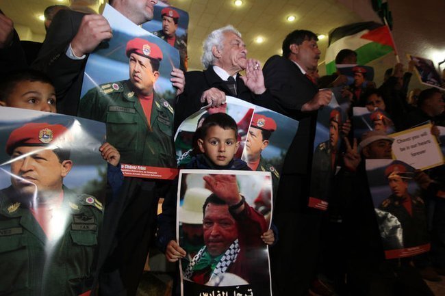 Палестинцы держат портреты президента Венесуэлы Уго Чавеса
