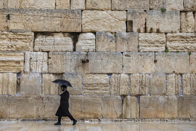 Религиозный еврей у Стены Плача под зонтом
