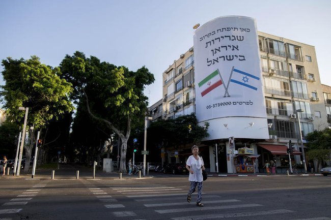 Плакат с надписью «Скоро здесь откроется посольство Ирана в Израиле» на доме в Тель-Авиве.