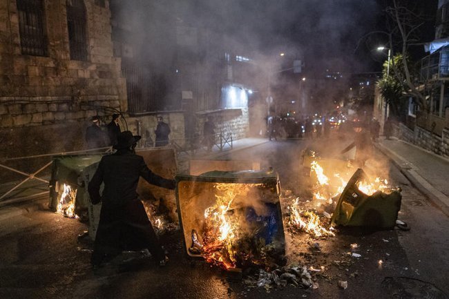 Ортодоксальный мужчина перекрывает дорогу и поджигает мусорные баки