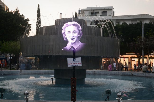 Голограммы с портретами выживших в Холокосте проецируются на фонтан на площади Дизенгоф в Тель-Авиве.