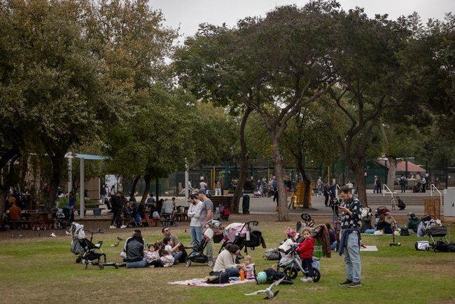 Люди отдыхают на траве в парке Израиля