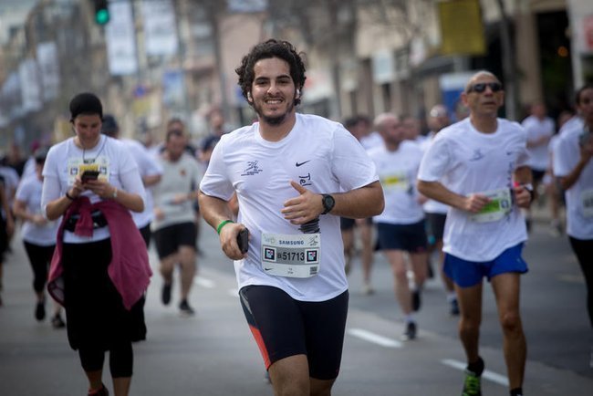 бегуны принимают участие в марафоне в Тель-Авиве