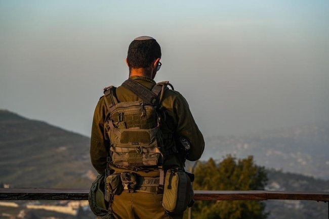 Израильский солдат наблюдает за южным Ливаном с наблюдательного пункта недалеко от границы