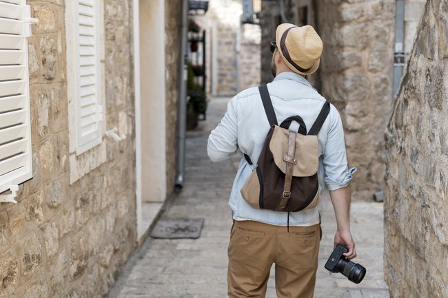 турист с фотоаппаратом гуляет по улицам европейского города
