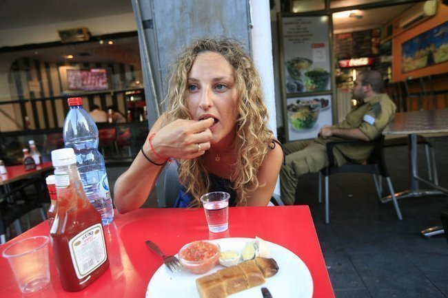 Молодая еврейская женщина ест джахнун — тесто, запеченное в духовке на медленном огне в течение 12–14 часов — в йеменском ресторане в Иерусалиме