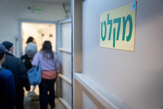 Жители Тель-Авива укрываются в бомбоубежище во время сирены, предупреждающей о запуске баллистических ракет из Ирана