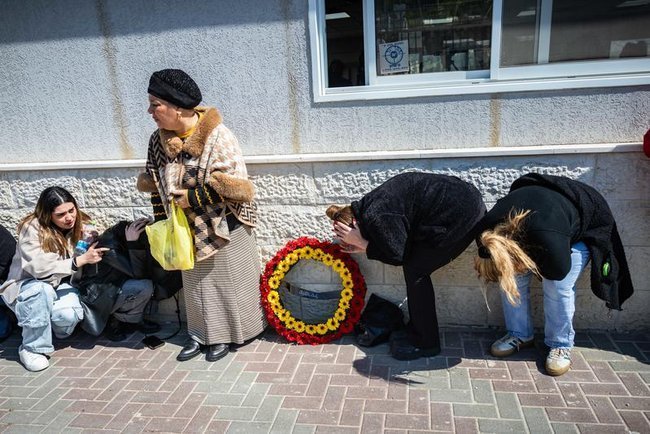 Друзья и родственники укрываются во время сирены на похоронах Ронит и Сары Элимелех, погибших в результате удара Ирана в Бейт-Шемеше