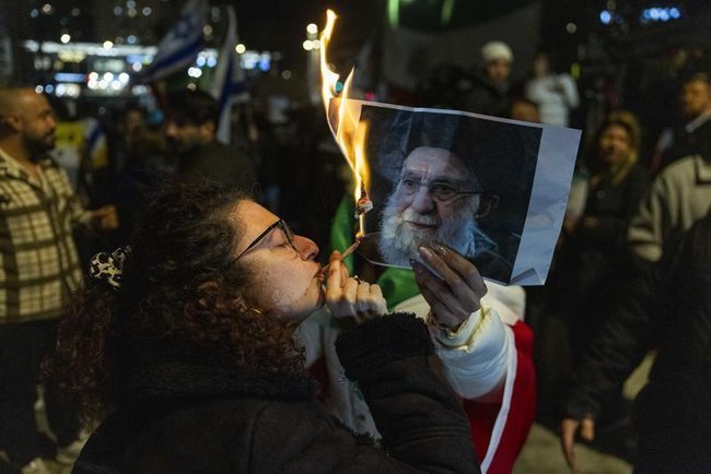 Представители иранской диаспоры сжигают портрет Хаменеи на демонстрации в Израиле.