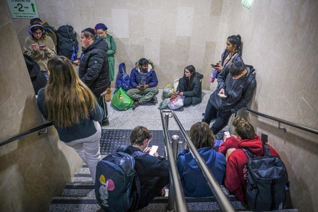 Пассажиры прячутся на железнодорожной станции Иерусалима во время воздушной тревоги.