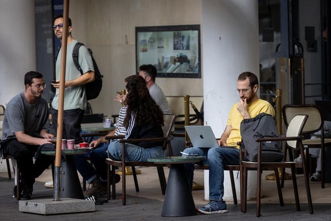 Мужчина с ноутбуком работает за столиком