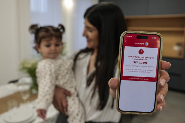 женщина с телефоном в руках на котором оповещение о воздушной тревоге