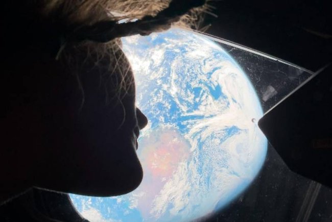 Астронавт Кристина Кох смотрит на Землю через иллюминатор «Ориона».