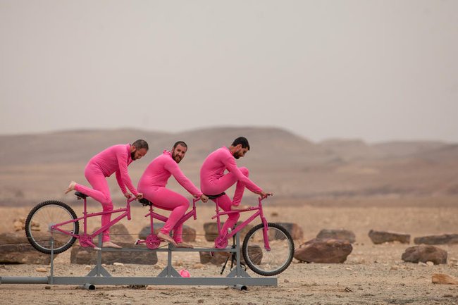 Болельщики в розовой одежде наблюдают за третьим этапом велогонки «Джиро д’Италия» на фоне кратера Махтеш-Рамон