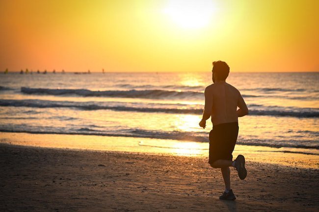 мужчина бежит по пляжу