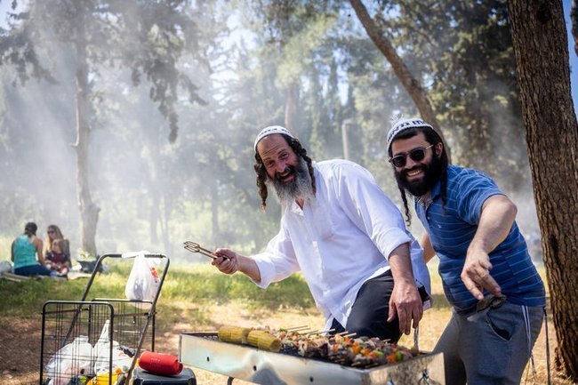 Израильтяне жарят мясо на мангале во время празднования Дня независимости Израиля