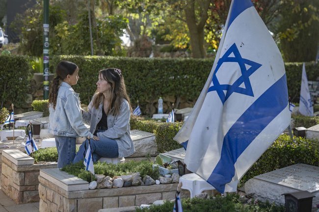 Семья на могиле военнослужащего в День памяти