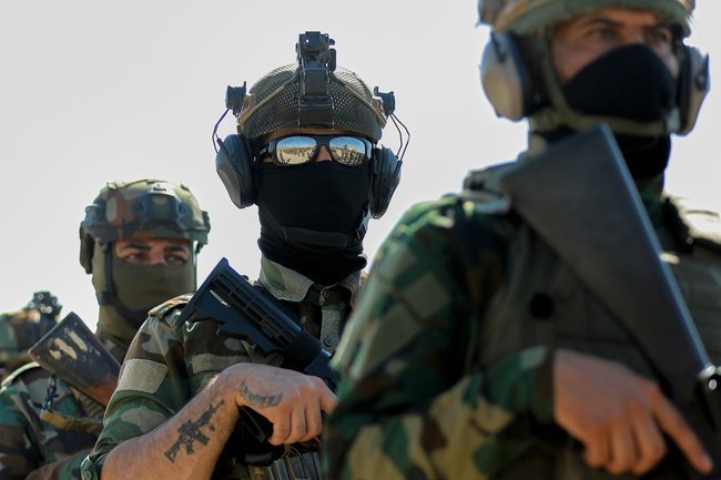 Боевики одной из шиитских милиций в Ираке сдают оружие государству в июне 2026 года.