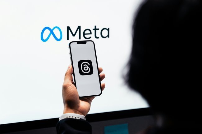 телефон в руке и логотип Meta