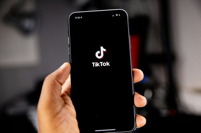 Телефон в руках с приложением TikTok
