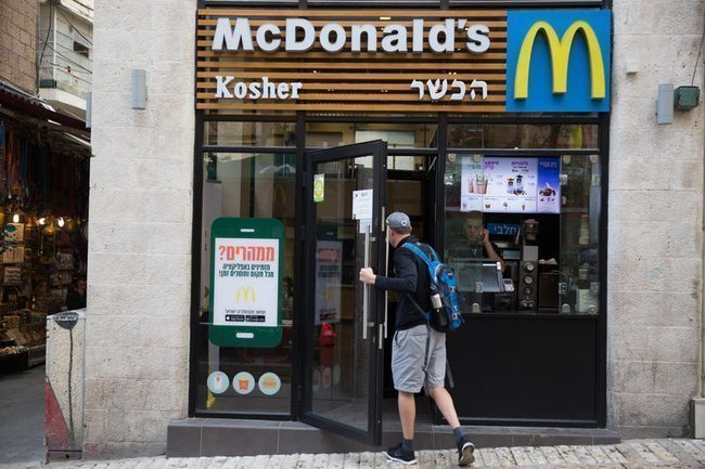 Человек идет за Биг Маком в иерусалимский McDonald's.