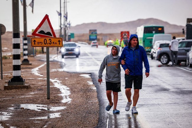 люди в пустыне Негев во время дождя