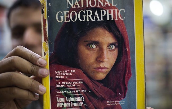 Владелец книжного магазина в Исламабаде показывает выпуск National Geographic со знаменитым портретом «афганской девочки»