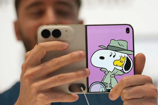 Сотрудник Apple демонстрирует складной iPhone Duo в магазине в Лондоне